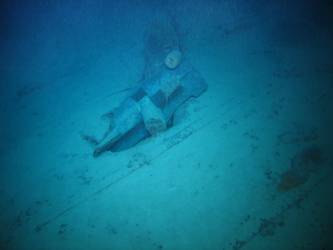 Stbd anchor embedded in steel plate from ship's side in debris field